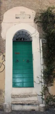 a green door on the side of a building at Moro 50 - Loft in Trastevere in Rome