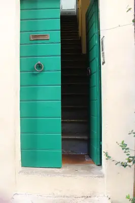 a green door with stairs in front of a house at Moro 50 - Loft in Trastevere in Rome
