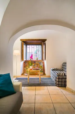 a living room with a table and a window at Moro 50 - Loft in Trastevere in Rome