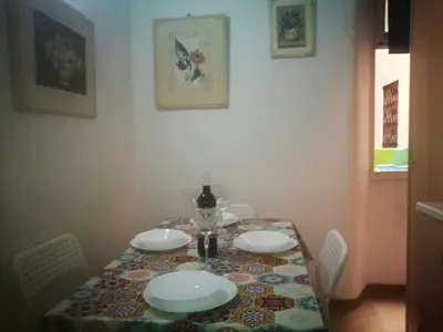 a table with plates and a bottle of wine on it at Gisa Apartment in Rome