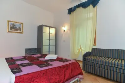 a bedroom with a bed and a couch in it at Gisa Apartment in Rome