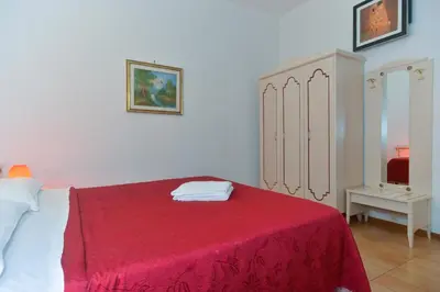 a bedroom with a bed with a red blanket at Gisa Apartment in Rome