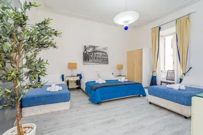a bedroom with two beds and a potted tree at White Vatican in Rome