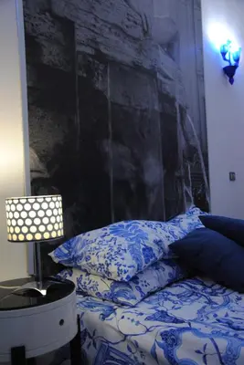 a bedroom with a bed with blue and white pillows at White Vatican in Rome