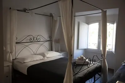 a bedroom with a black canopy bed with a window at White Vatican in Rome