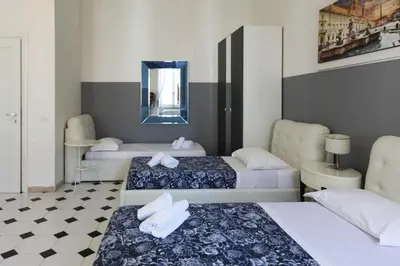 a hotel room with three beds and a mirror at White Vatican in Rome