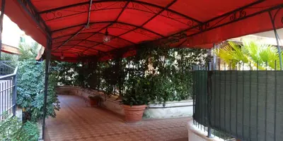 a tree next to a house and a building at Aurelia Begonia Apartment - family & business in Rome