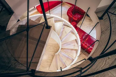 a spiral staircase in a building with a red bench at Restart Accommodations Borghese in Rome