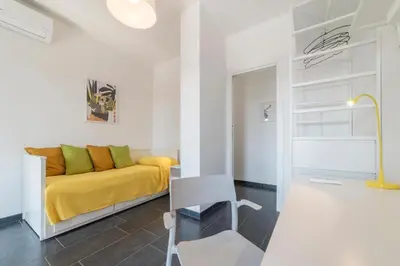 a living room with a yellow bed and a chair at Charming Apartment in Rome + Internet in Rome