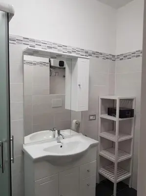a white bathroom with a sink and a mirror at Charming Apartment in Rome + Internet in Rome