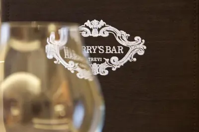 a wine glass with a kings bar logo on it at Harry's Bar Trevi Luxury Apartments - Spagna in Rome
