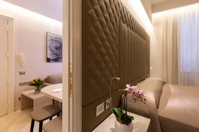a hotel room with a bed and a desk and a table at Harry's Bar Trevi Luxury Apartments - Spagna in Rome