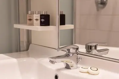 a bathroom sink with a faucet in front of a mirror at Harry's Bar Trevi Luxury Apartments - Spagna in Rome