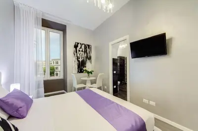 a bedroom with a bed and a table and a mirror at B&B Colosseo Panoramic Rooms in Rome