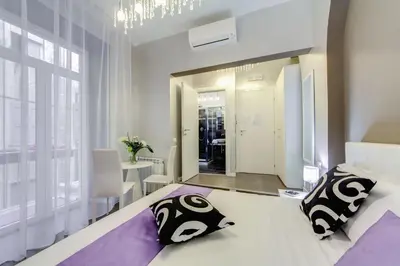 a bedroom with a white bed and purple walls at B&B Colosseo Panoramic Rooms in Rome