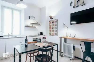 a kitchen with a table and chairs and a television at Restart Accommodations Aldobrandini e Sciarra in Rome