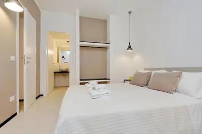 a white bedroom with a large white bed and a bathroom at Restart Accommodations Aldobrandini e Sciarra in Rome
