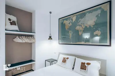 a bedroom with a map of the world on the wall at Restart Accommodations Aldobrandini e Sciarra in Rome