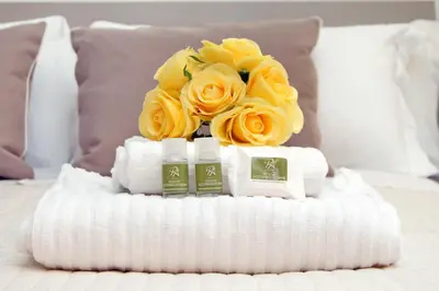 a bouquet of yellow roses sitting on top of a bed at Restart Accommodations Aldobrandini e Sciarra in Rome