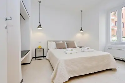 a white bedroom with a large bed and a window at Restart Accommodations Aldobrandini e Sciarra in Rome