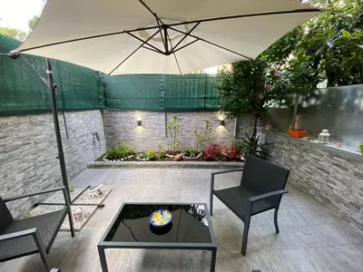 a patio with an umbrella and chairs and a table at Mimma's House Private Garden near Trastevere in Rome