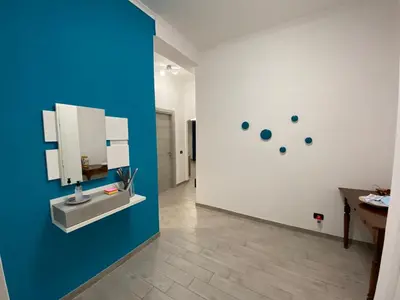 a bathroom with a blue wall with a mirror at Mimma's House Private Garden near Trastevere in Rome