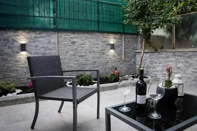 a table with a chair and two wine glasses at Mimma's House Private Garden near Trastevere in Rome