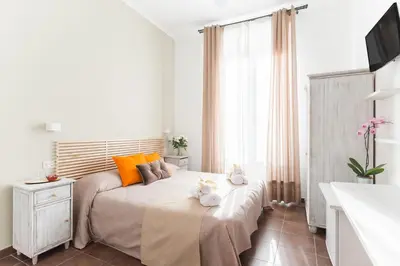 a bedroom with a bed with orange pillows and a television at Domus Victoria Guest House in Rome