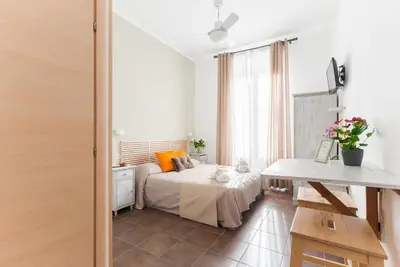 a bedroom with a bed with orange pillows and a table at Domus Victoria Guest House in Rome