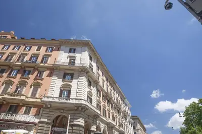 a tall building with a balcony on the side of it at Domus Victoria Guest House in Rome