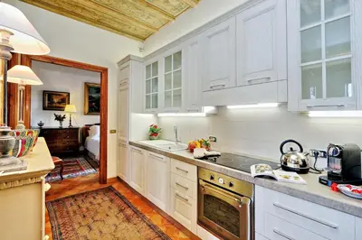 a kitchen with white cabinets and a stove top oven at TreasureRome Daphne Terrace in Rome