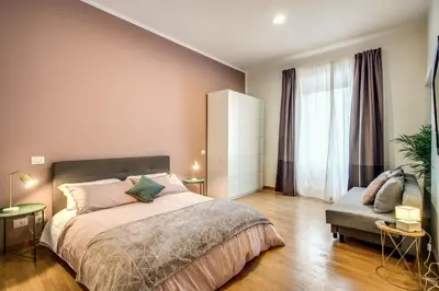 a bedroom with a large bed and a chair at Diocleziano Triple in Rome