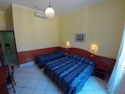 a bedroom with a bed with blue sheets on it at Hotel Ferrari in Rome