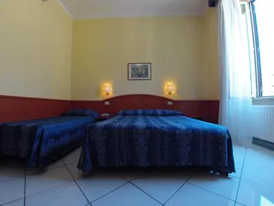 a bedroom with two beds and a window at Hotel Ferrari in Rome