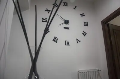a clock on a white wall with blackletters on it at TIME in Rome