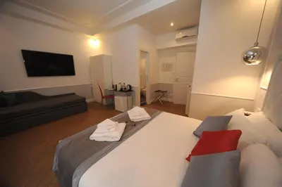 a bedroom with a large white bed and a couch at My Suites Piazza di Spagna in Rome