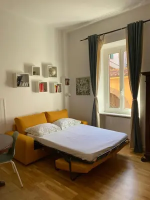 a bed in a room with a couch and a window at La casa di Remo in Rome