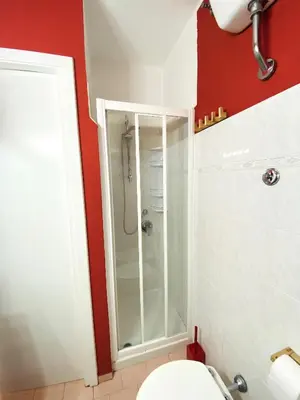 a bathroom with a shower and a white toilet at La casa di Remo in Rome