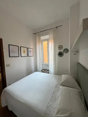 a bedroom with a large white bed and a window at La casa di Remo in Rome