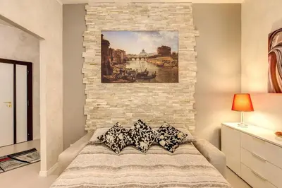a bedroom with a painting on a brick wall at GuestHouse near St.Peter in Rome