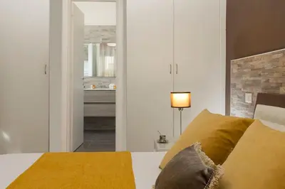 a bedroom with a bed with yellow pillows and a mirror at GuestHouse near St.Peter in Rome