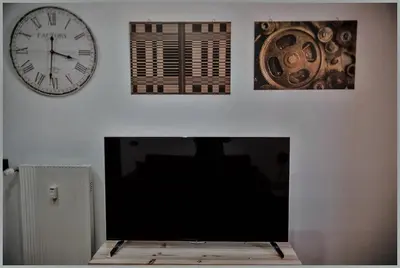 a living room with a clock and a television at Accogliente appartamento a Testaccio in Rome
