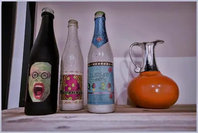 three bottles sitting on a table next to a pitcher at Accogliente appartamento a Testaccio in Rome
