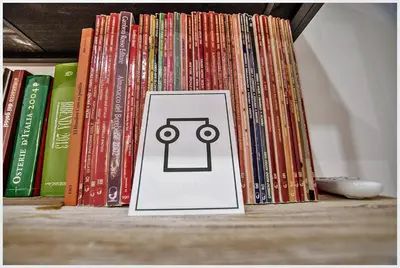 a pile of books on a book shelf with a playing card at Accogliente appartamento a Testaccio in Rome