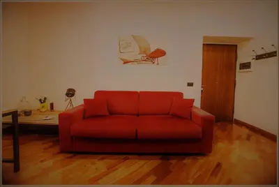 a red couch sitting in a living room at Accogliente appartamento a Testaccio in Rome