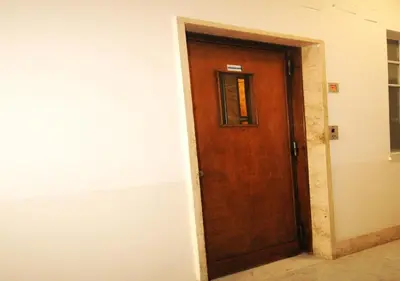 a wooden door in a room next to a wall at Viaggio da Bea al Gianicolo in Rome