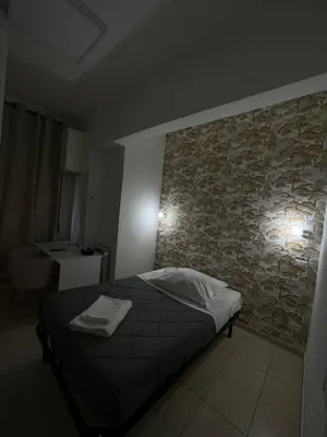 a bedroom with a bed and a stone wall at TIBURTINA INN GUEST HOUSE in Rome
