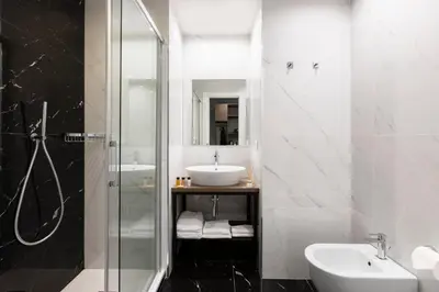 a white bathroom with a sink and a shower at Giubbonari Suites in Rome