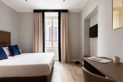 a bedroom with a bed and a desk and a window at Giubbonari Suites in Rome