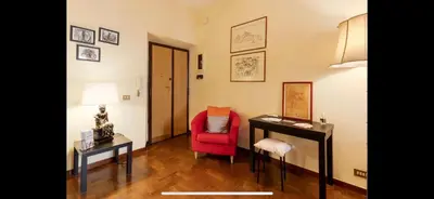 a living room with a red chair and a table at Center Rome Coliseum in Rome